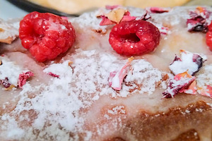 Cake with a golden-brown crust, topped sugar and raspberries, a Food & Drink Photo by DanFLCreativo