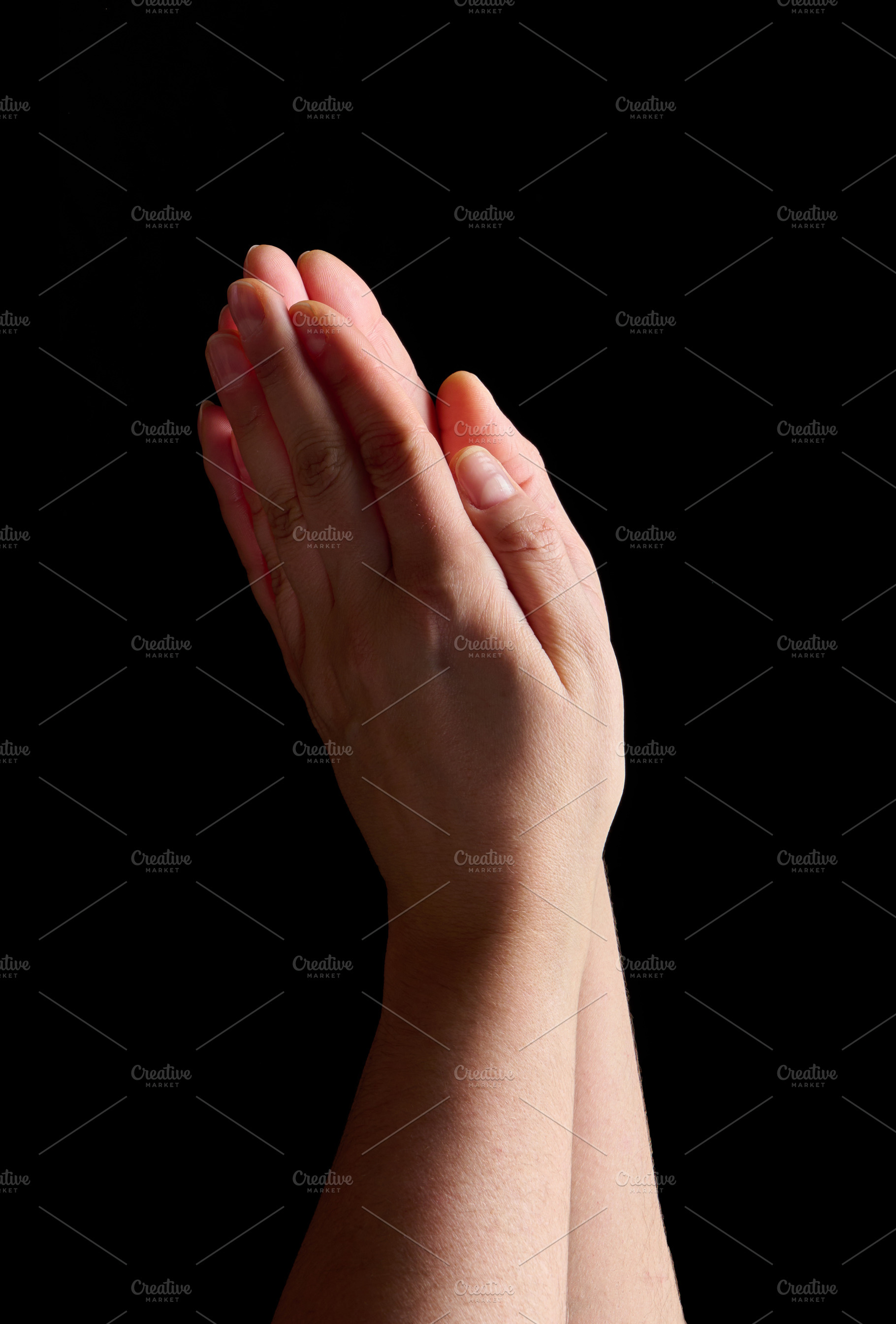 Two palms folded together in a prayer gesture on a black backgro, a Person Photo by ndanko