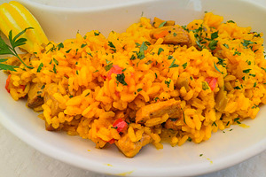 Saffron rice with chicken and vegetables in oval plate, a Food & Drink Photo by DanFLCreativo