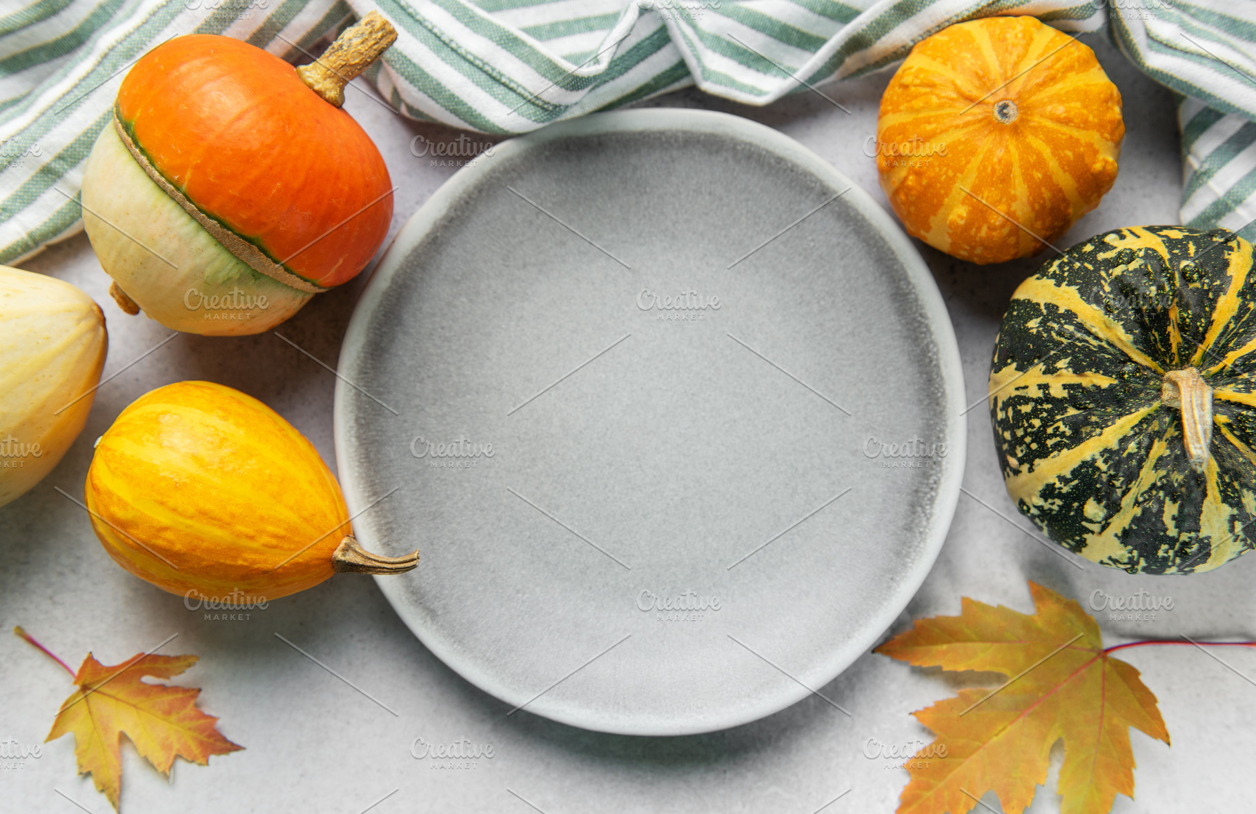 Empty plate surrounded by autumn gourds and leaves, a Food & Drink Photo by Olena Rudo