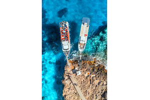 Aerial view of boat and rocky sea, a Transportation Photo by den-belitsky