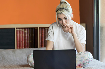 Photo of young joyful woman in pajama typing on laptop and smiling while sittin, a Person Photo by 2Design