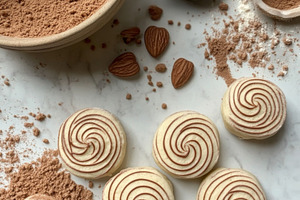Almond swirl cookies with cocoa powder and ingredients on marble, a Photo by Dvoevnore photos