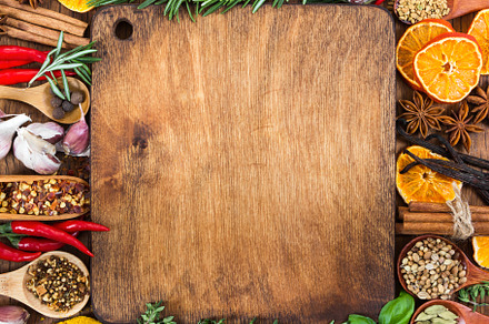 Various spices around cutting board, a Food & Drink Photo by Nataliia Pyzhova