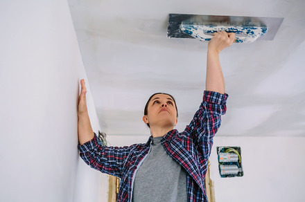 Bricklayer smoothing plaster ceiling with the trowel, a Person Photo by davidpereiras