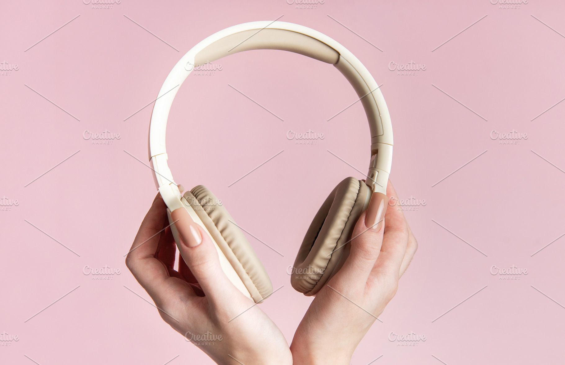 Woman holding wireless headphones on pink background, a Technology Photo by Olena Rudo