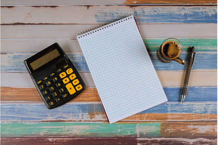 Notebook calculator and pen with cup, a Business Photo by Ungvar Studio