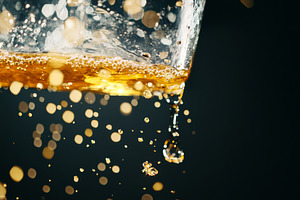 Amber-colored liquid and water splas, a Photo by Dvoevnore photos