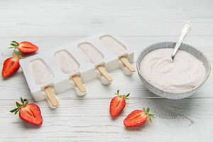 Homemade strawberry yogurt popsicles chilling in mold, a Food & Drink Photo by Olena Rudo