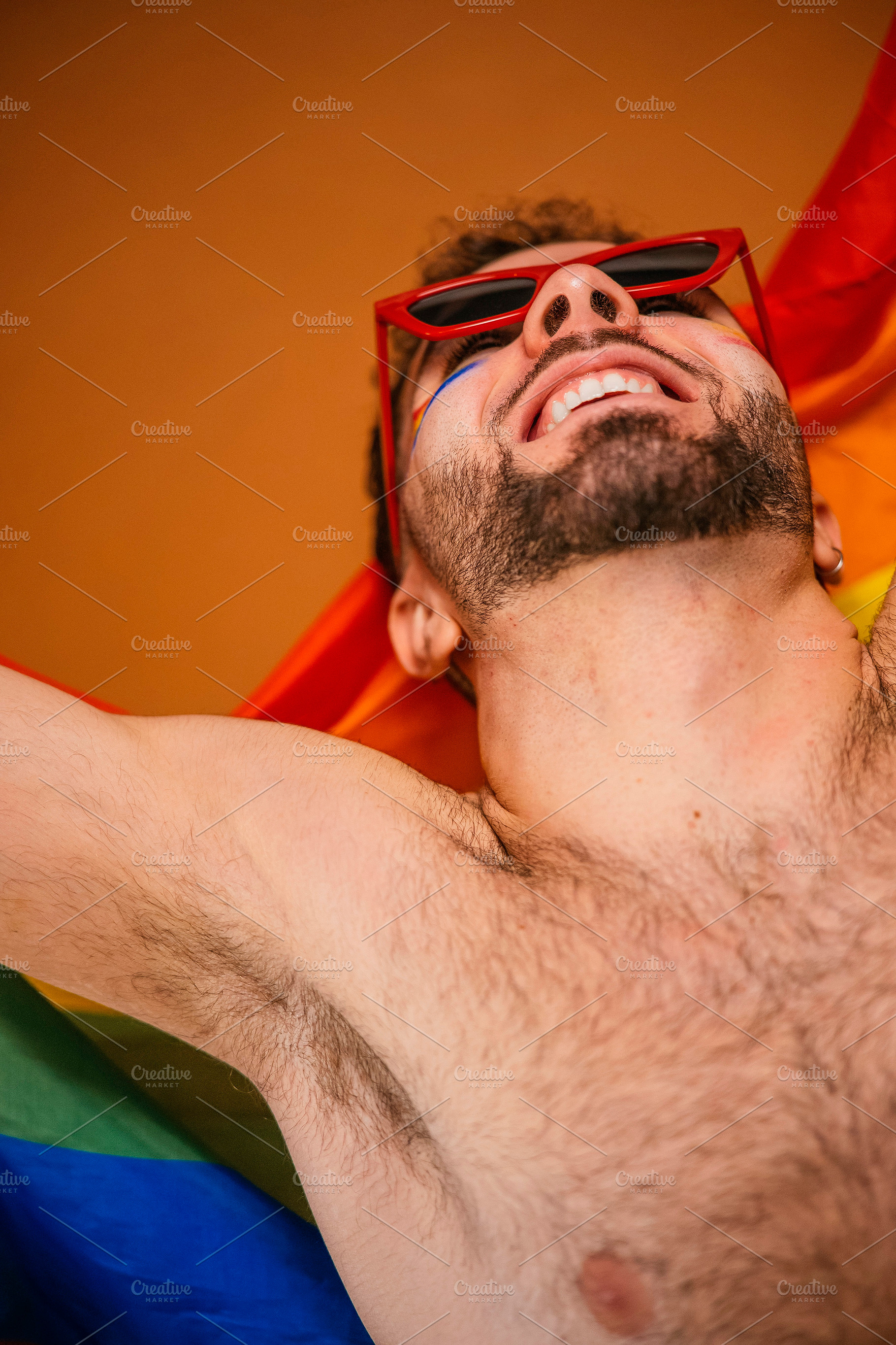 Man with rainbow flag celebrating lgbtq+ pride, a Photo by karrastock