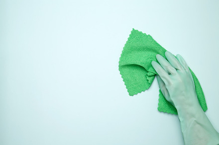 Womans hand in rubber glove holds cloths. House cleaning. Copy space, a Photo by matucha