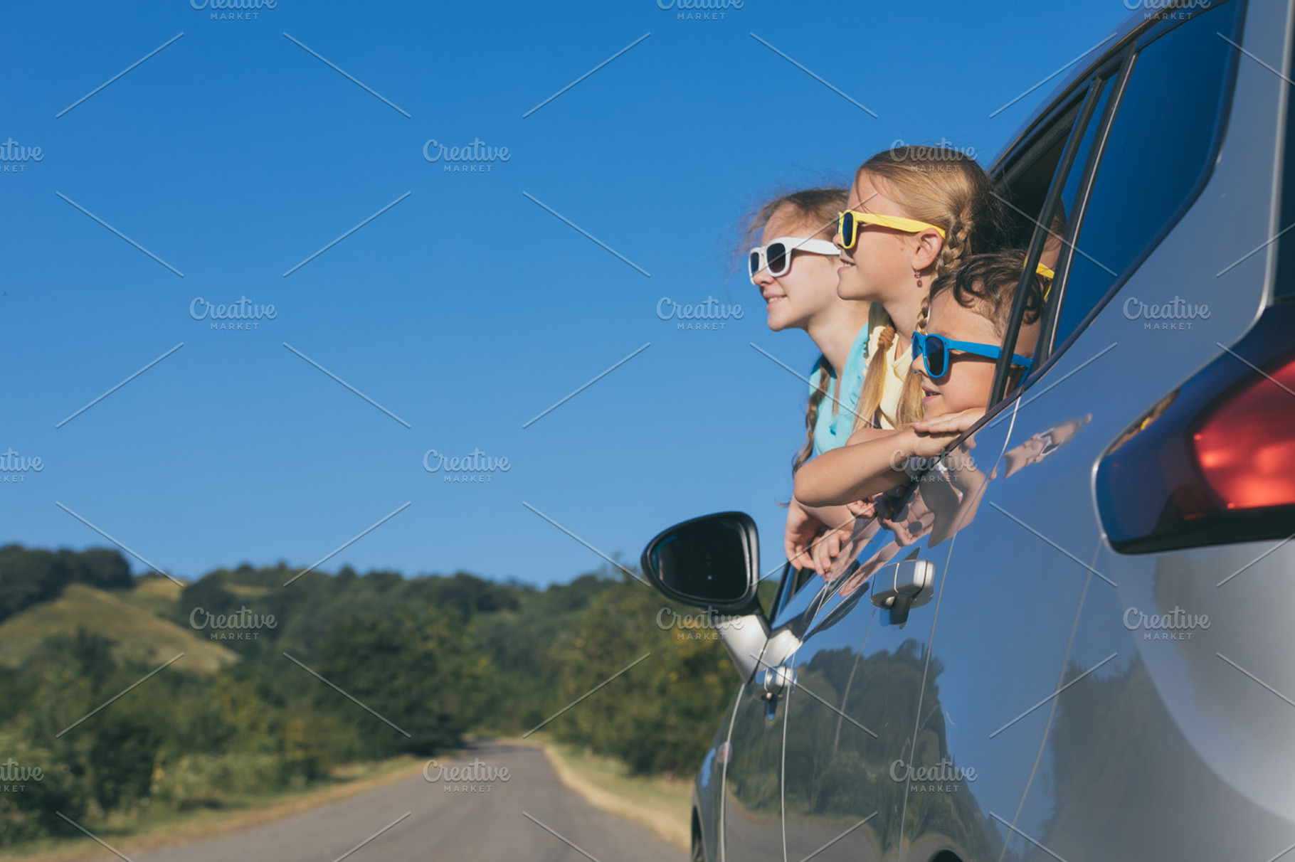 Happy kids sitting in the car containing car, child, and family, a Transportation Photo by altanaka