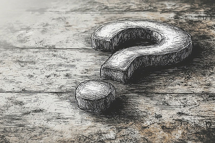 Hand drawn question mark on textured wooden surface