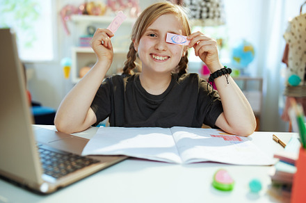 smiling child having distance education and fooling around, a School & Education Photo by Alliance Images