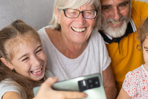 Happy grandparents and grandchildren taking a selfie together at home, a Person Photo by etorres69
