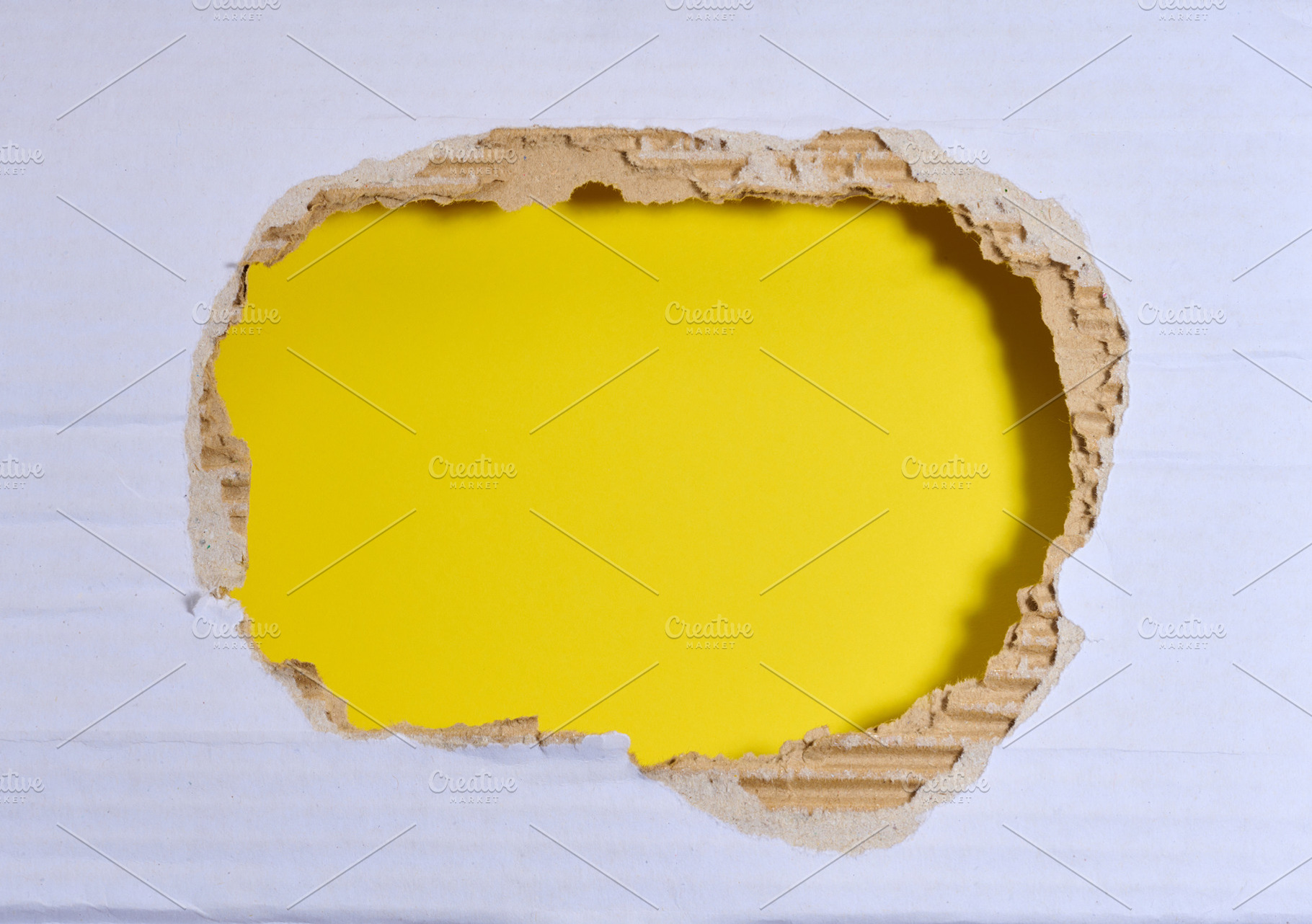 A torn hole in white paper with a yellow background inside., a Background Photo by ndanko