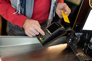 Unrecognizable male customer paying with credit card, a Photo by Prostock-Studio
