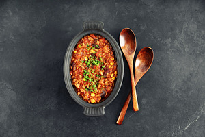 Mexican Chili Con Carne with Wooden Spoons on Dark Background, a Food & Drink Photo by Natalia Klenova's Shop