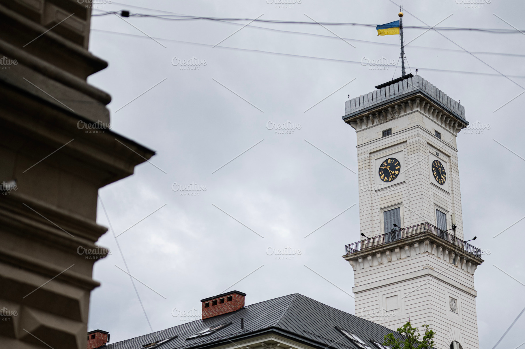 Clock tower with national flag on a cloudy day in Lviv, Ukraine., a Photo by AS photostudio
