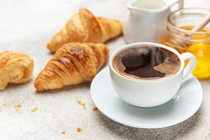 Steaming coffee, fresh croissants, and honey create a tempting b, a Food & Drink Photo by Olena Rudo