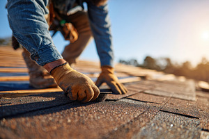 Skilled worker installs new shingles on rooftop during bright day in residentia, an Industrial Photo by AlyaAnd