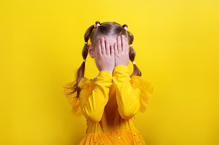 A portrait of a young girl in a yellow dress with braids, comple