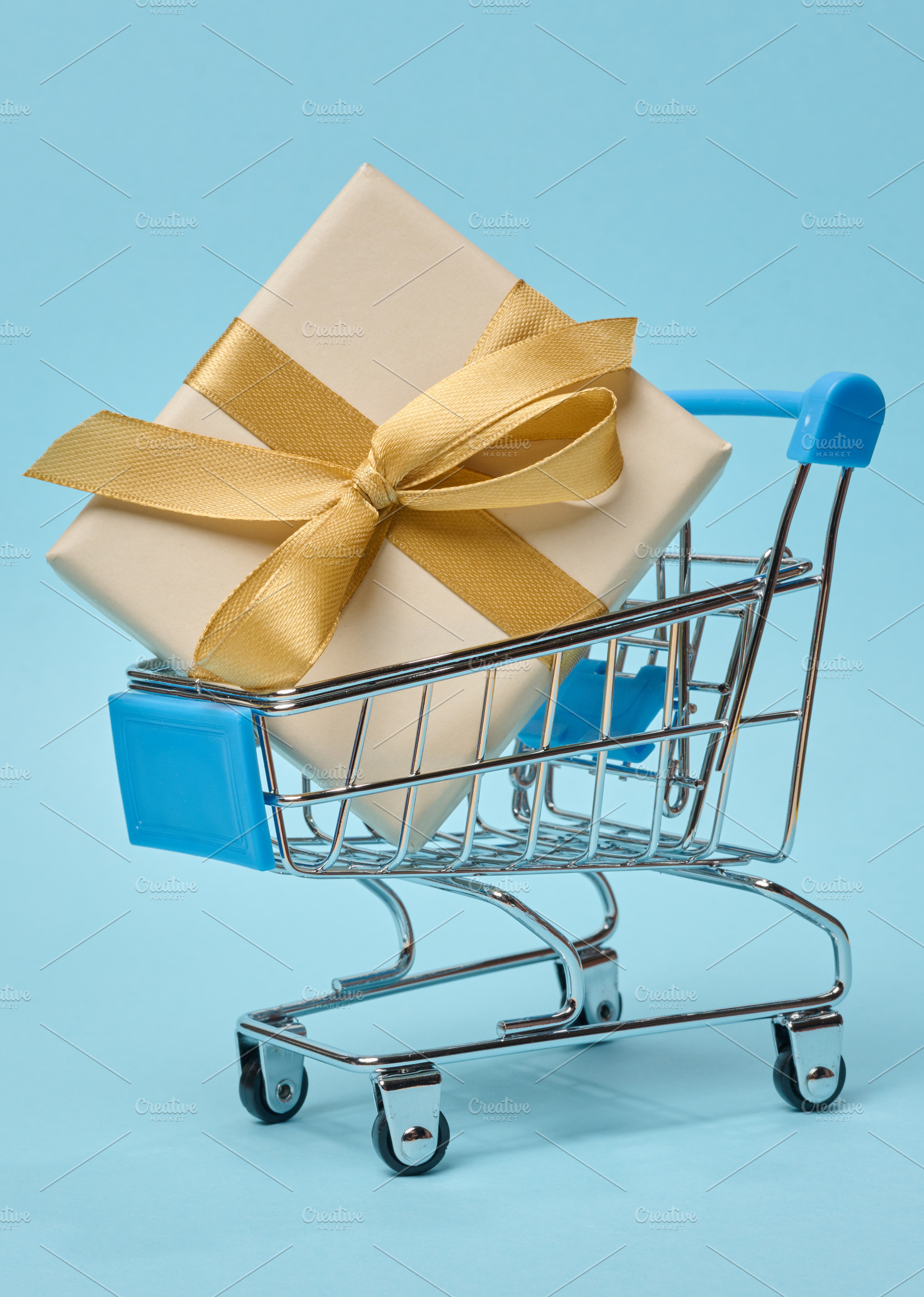 Miniature shopping cart with gift box, beige packaging, blue ba, a Holiday Photo by ndanko