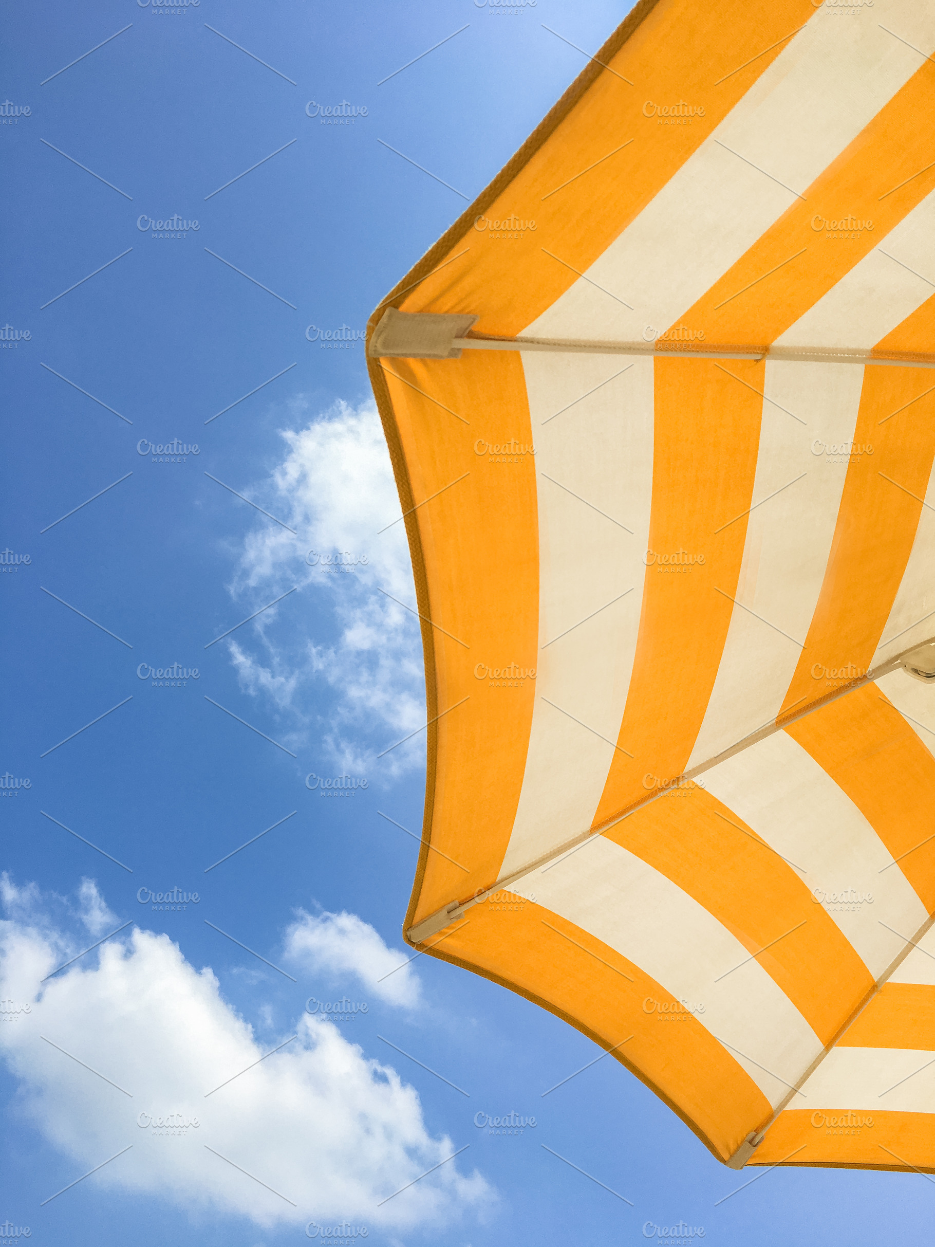 Yellow umbrella on the beach, an Abstract Photo by KYNA STUDIO