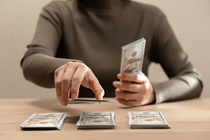 Sorting cash money into piles on a wooden table. Personal financ, a Photo by salmon.black
