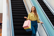 Lady Holding Shopping Bags Standing On Moving Stairs In Mall, a Photo by Prostock-Studio (Thumbnail 1 of 2)