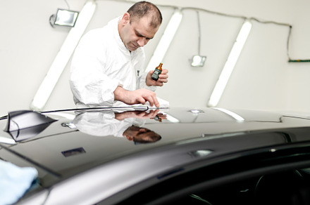 Man on a car wash polishing car with a polish machine containing car, auto