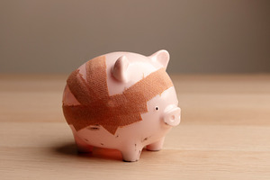 Damaged piggy bank with bandage, Fragile economy and financial c, a Photo by salmon.black