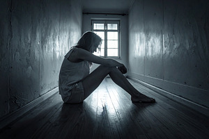 Sad woman sitting on floor in dark narrow hallway, a Person Photo by DanFLCreativo