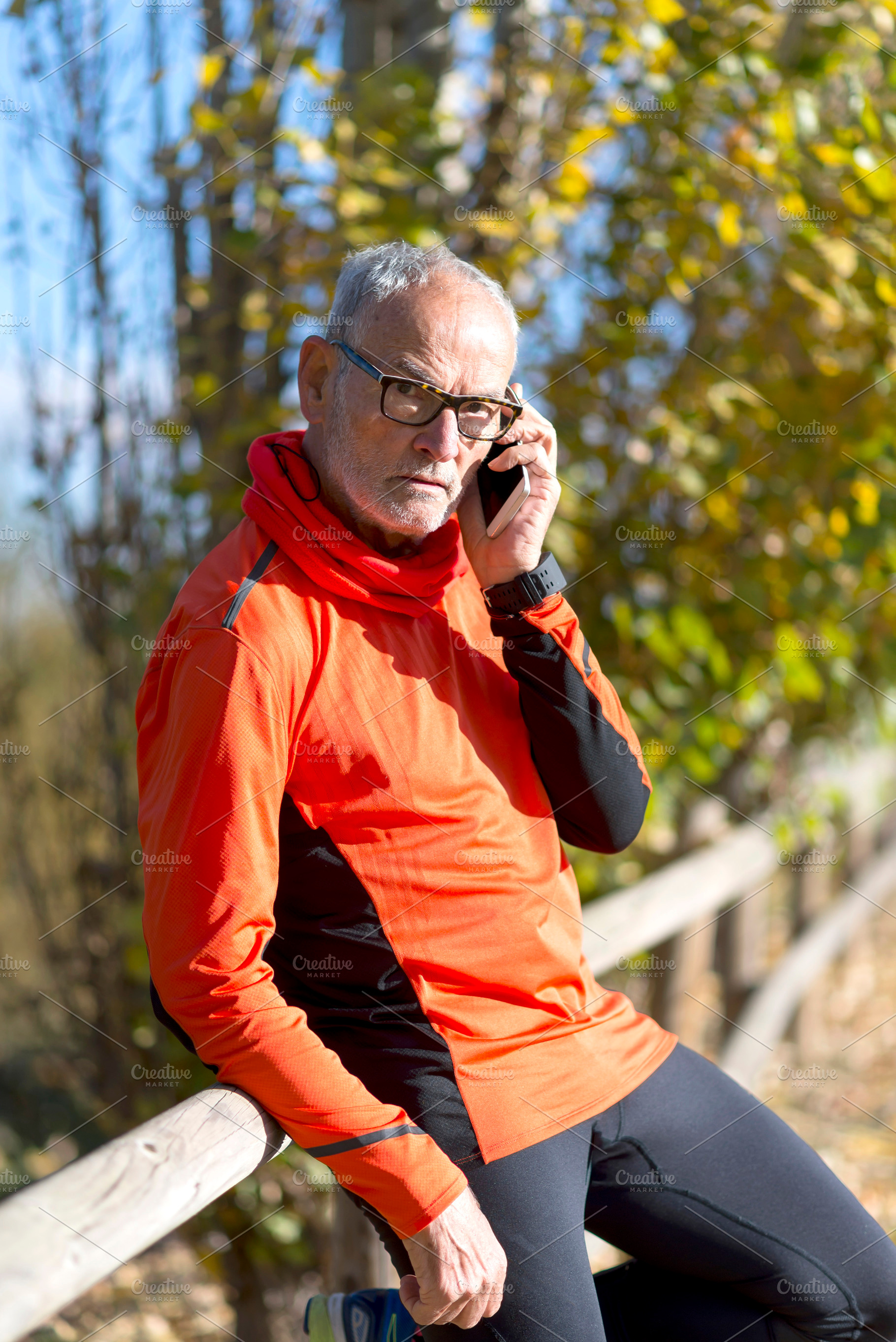 Senior man in sportswear talking on phone outdoors, a Sports & Recreation Photo by RF Images
