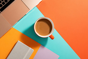 Flat lay of a stylish workspace with a laptop and coffee cup on colorful desk s, a Food & Drink Photo by AlyaAnd