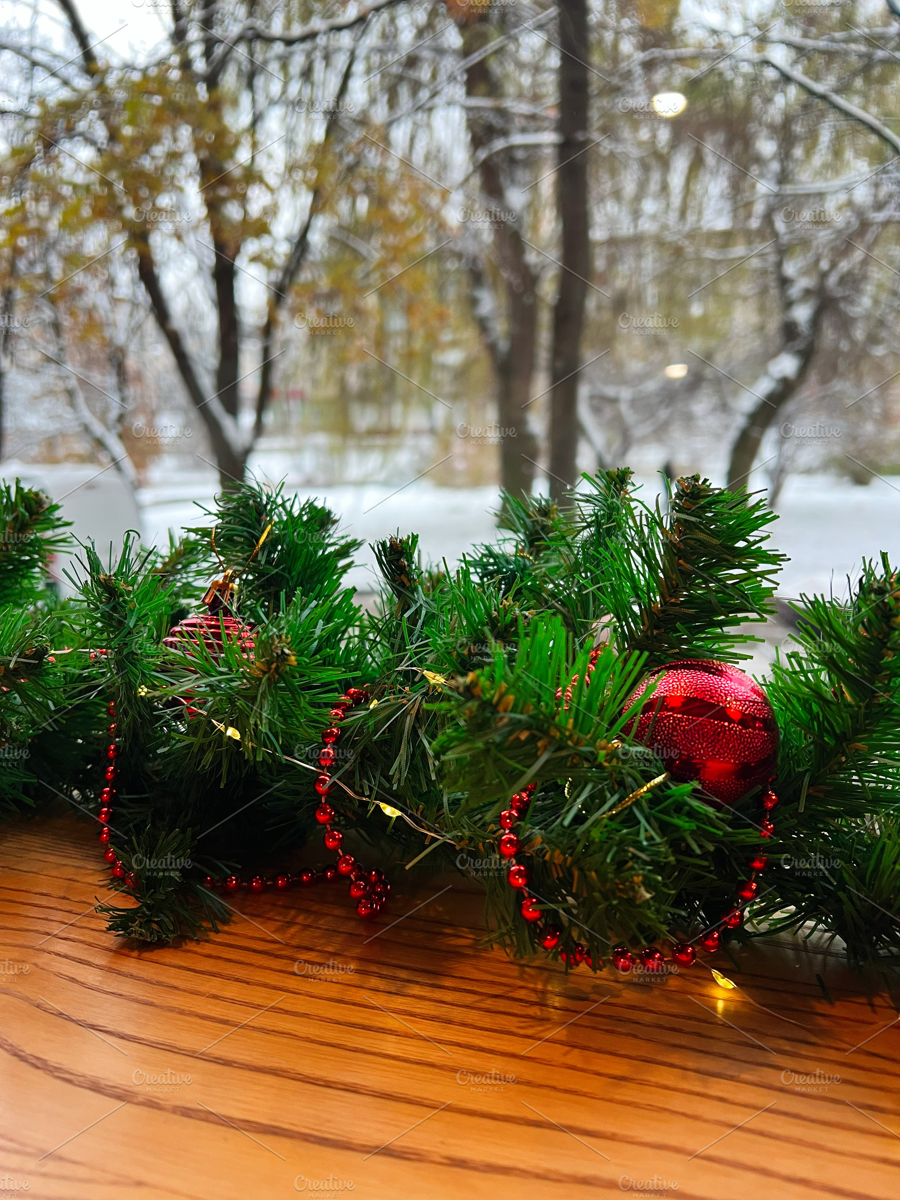 Festive Christmas garland decorating a window sill in winter, a Photo by AS photostudio