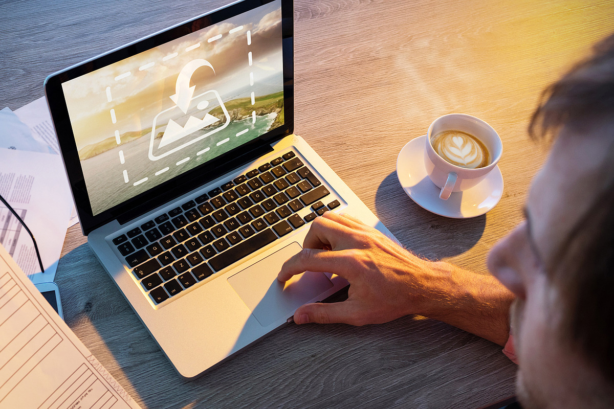 Man Reading And Using Laptop Mockup, a Marketing Template by wavebreak