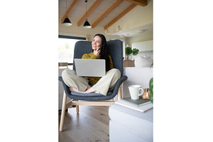 Woman working on laptop in cozy, a Person Photo by HalfPoint
