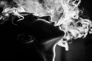 Woman exhales smoke in dramatic side, a Person Photo by MistyDay
