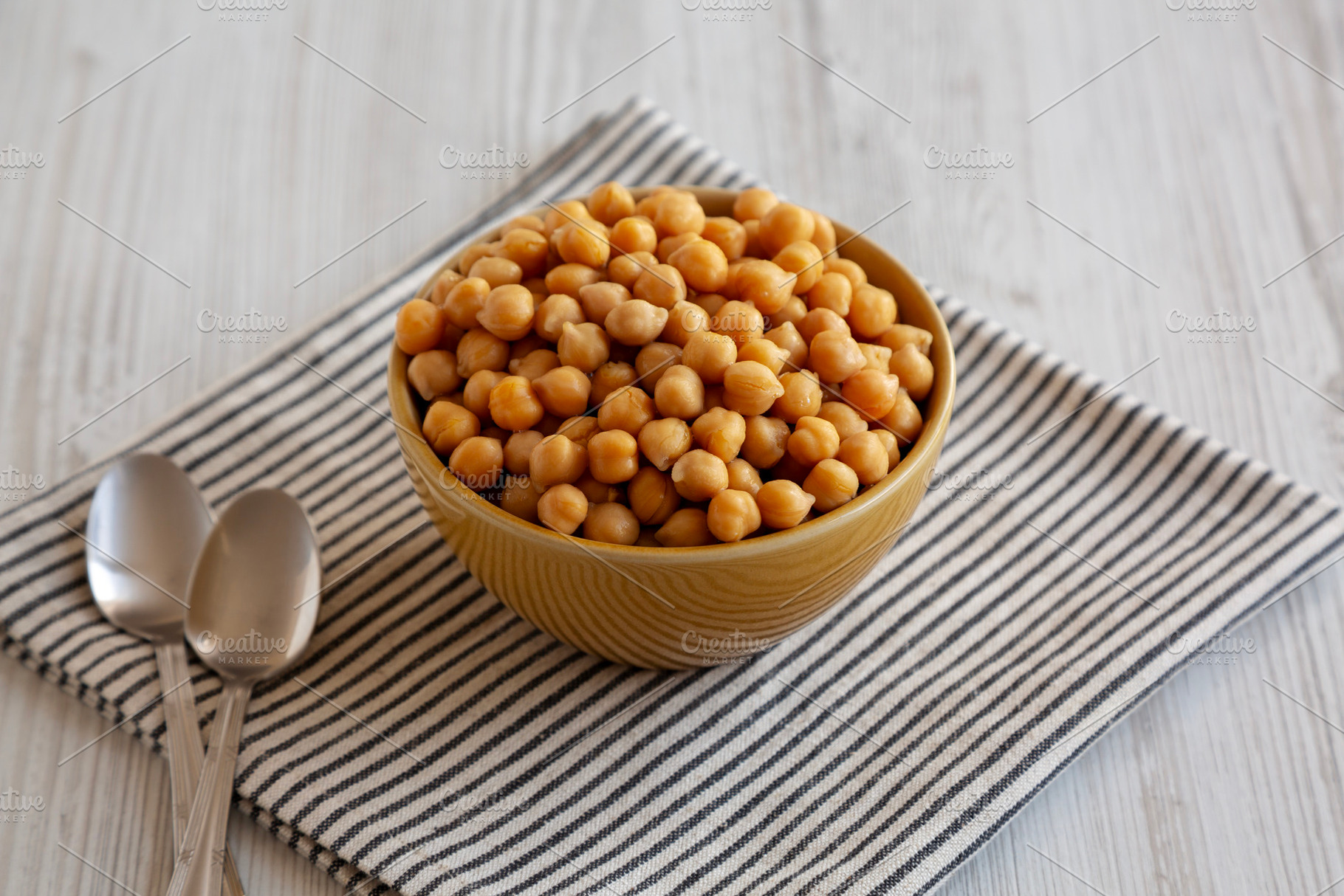 Organic Raw Canned Chickpeas in a Bowl, side view., a Food & Drink Photo by LiudmylaChuhunova