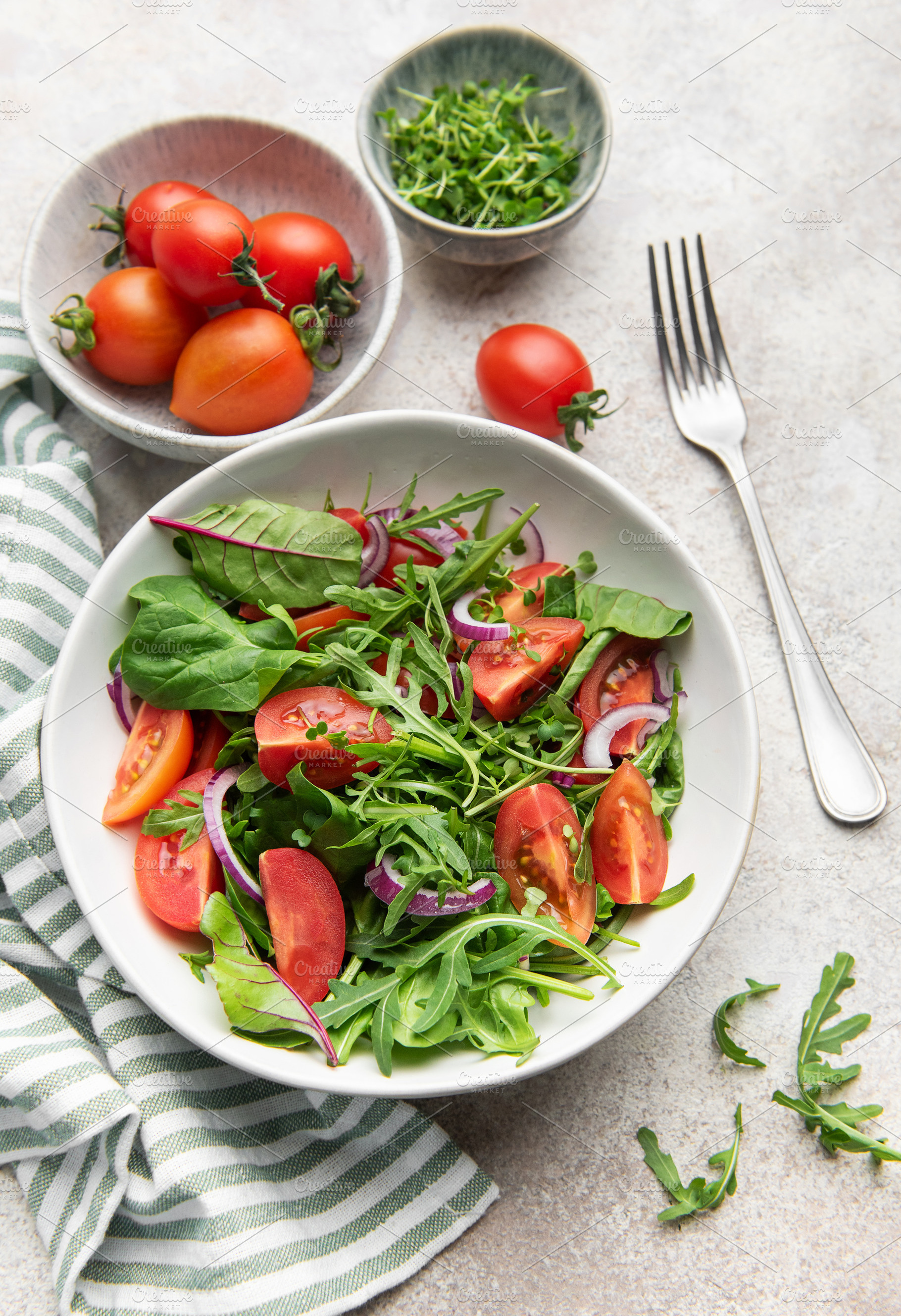 Fresh green salad with tomatoes and red onion, a Food & Drink Photo by Olena Rudo