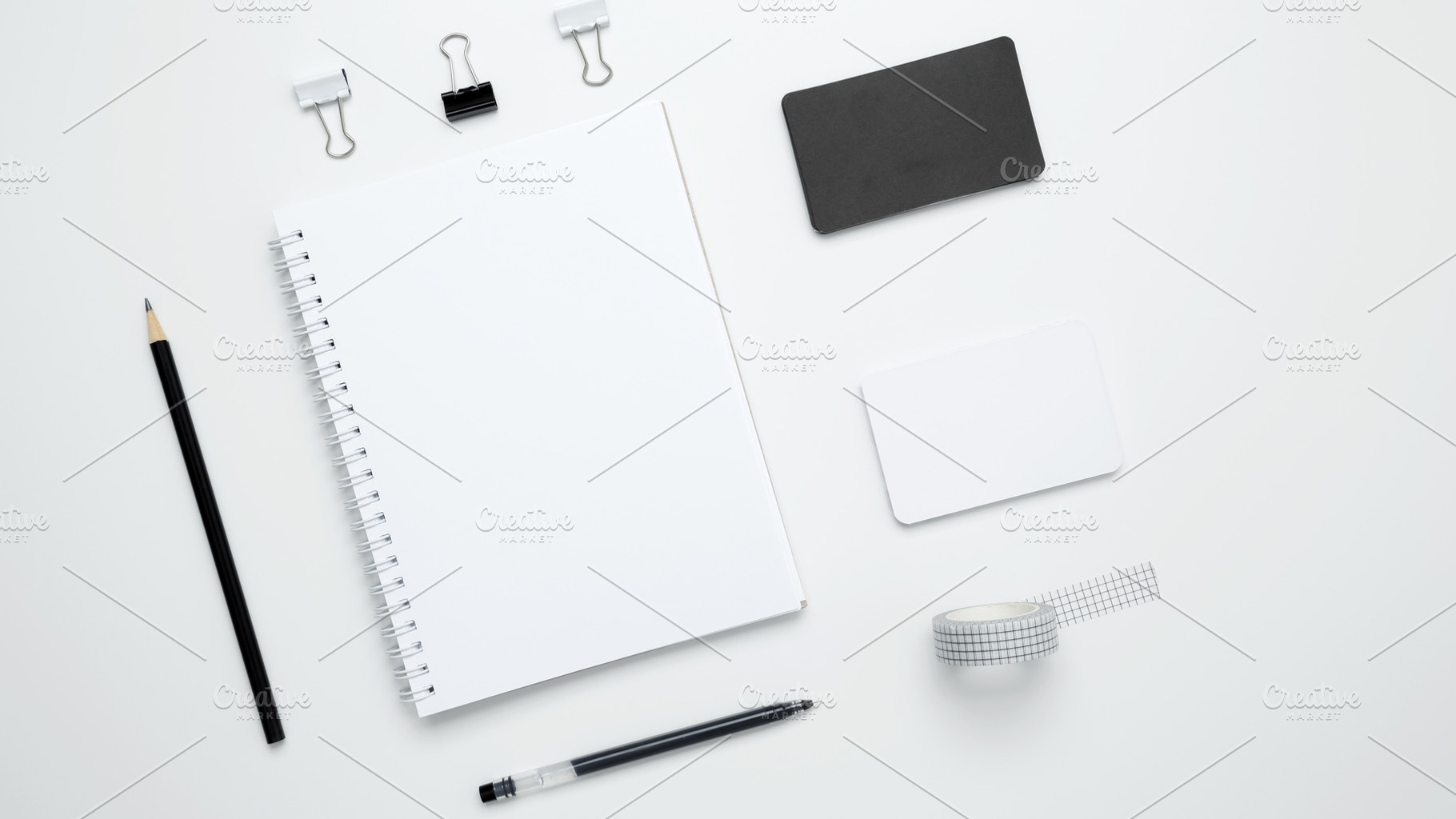 Monochrome stationery items. On a white background, an empty mock up notebook,, a Photo by matucha
