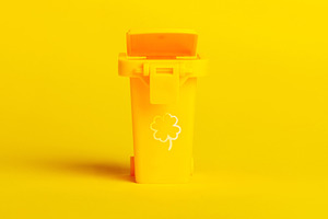 Minimalist yellow trash bin with clover icon, isolated on vibrant yellow backgr, a Technology Photo by Ales Munt