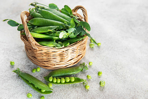 Fresh green peas pods in a wicker basket, a Food & Drink Photo by Olena Rudo
