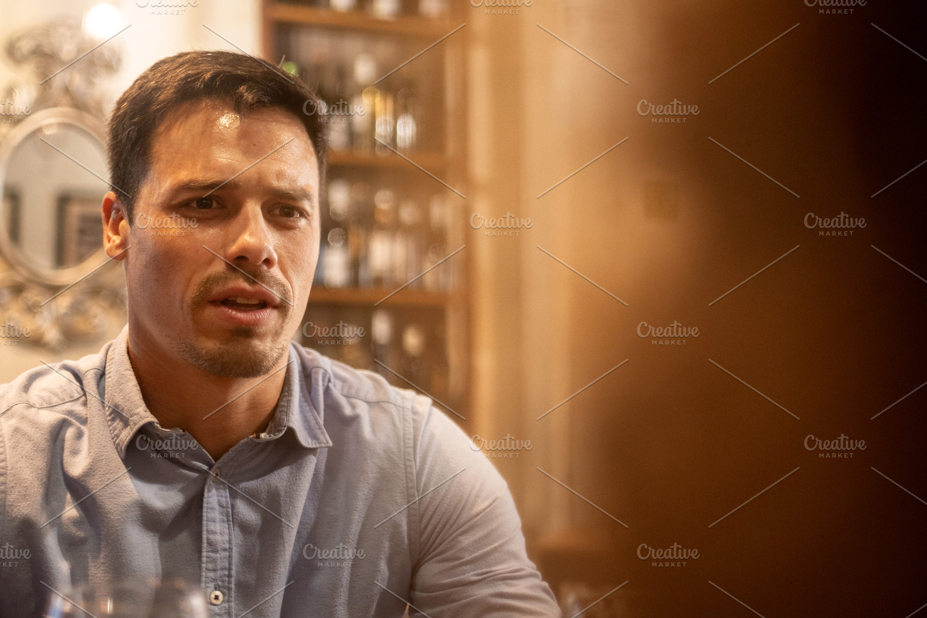 Serious young man talking during dinner date at cozy restaurant, a Person Photo by etorres69