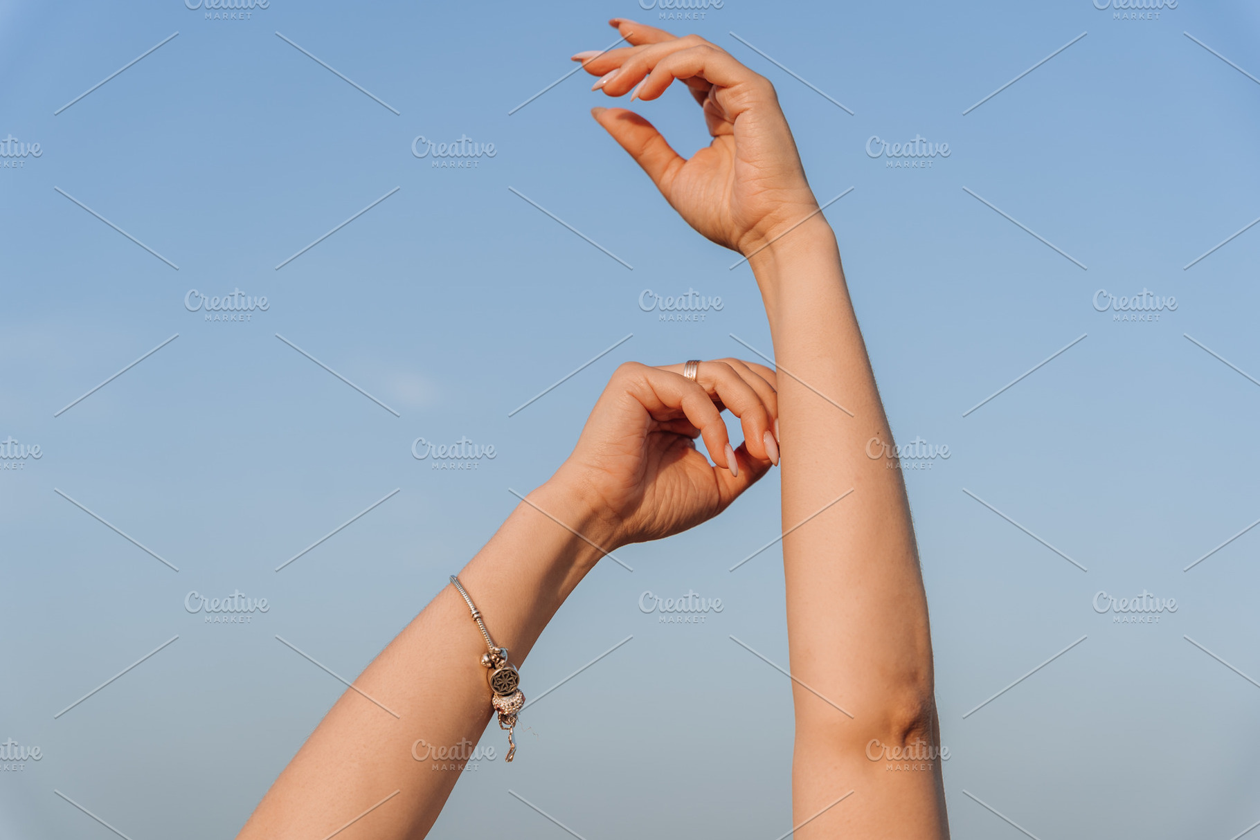 Female Arms and Hands Raised Against Clear Blue Sky, a Person Photo by Red Hot Chili Pepper Shop