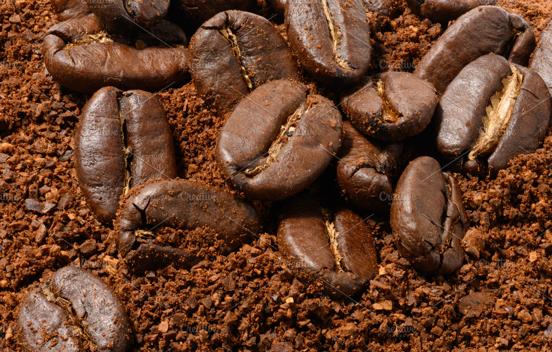 Roasted coffee beans lie on an even layer of freshly ground brow, a Food & Drink Photo by ndanko