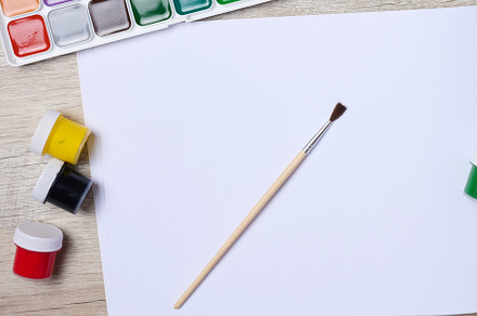 Open sketchbook with blank white sheets and acrylic paints, top, a School & Education Photo by ndanko