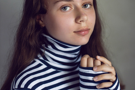 portrait of a serious Caucasian teenage girl in a striped jacket against a gray, a Person Photo by SaulichPhoto