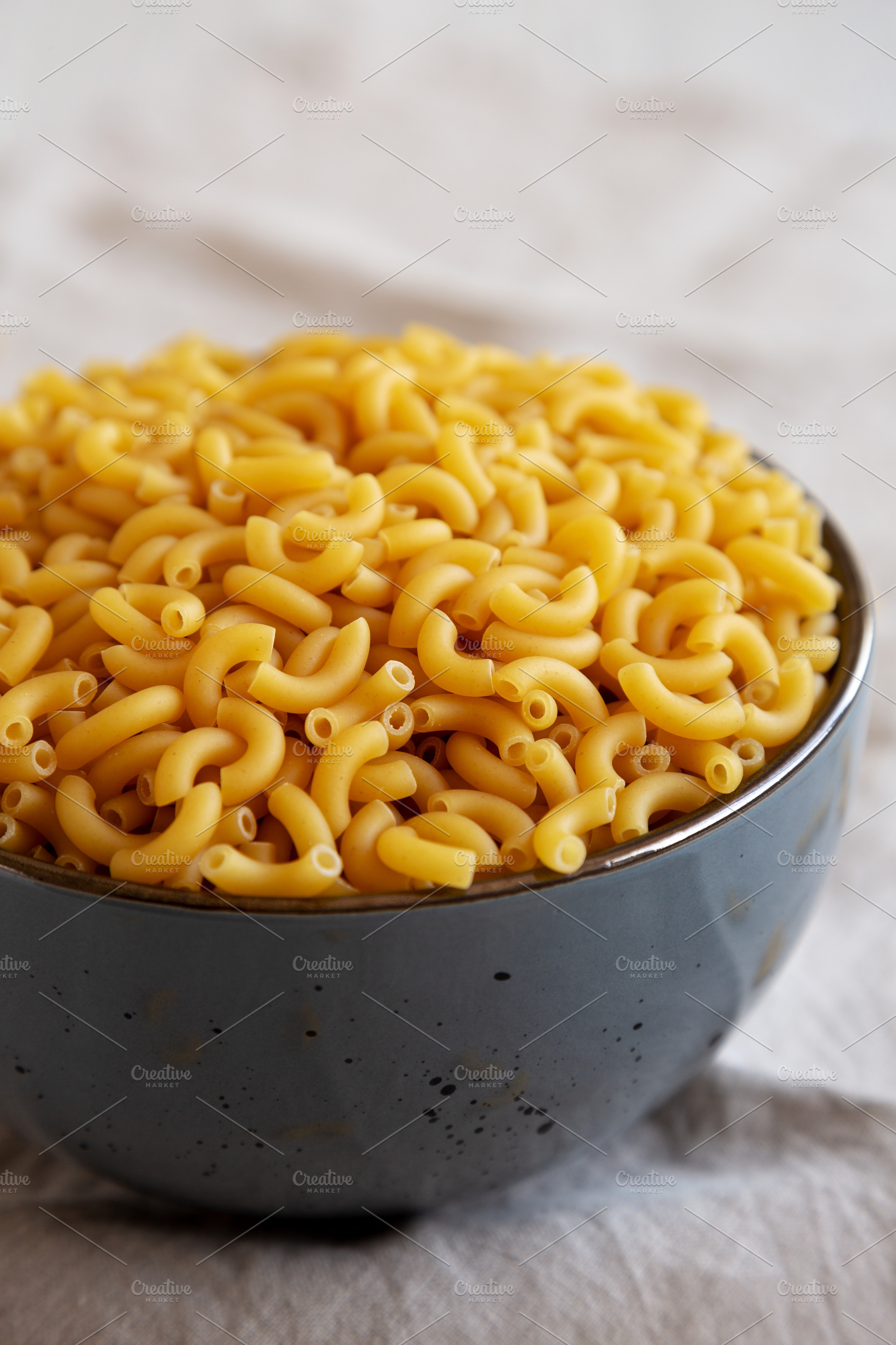 Bowl of Dry Organic Macaroni Elbow Pasta, Ready to be Cooked. Cl, a Food & Drink Photo by LiudmylaChuhunova